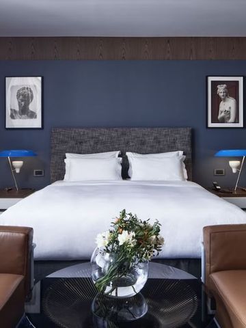 Hotelzimmer mit Blumenarrangement und Designerlampen.