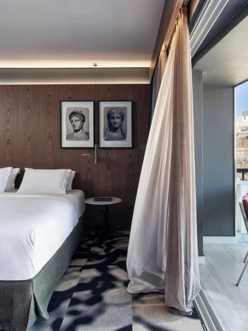 Zimmer mit Balkon und Blick auf historische Architektur.