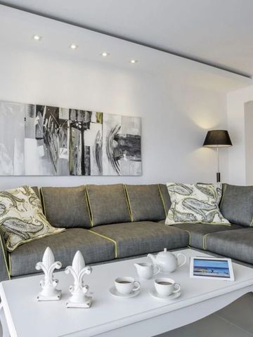 Elegantes Wohnzimmer mit grauem Ecksofa und Teeservice auf modernem Tisch