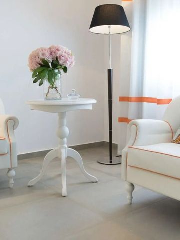 Elegantes Zimmer mit weißen Sesseln, Tisch und Blumen