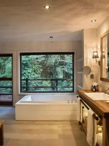 Modernes Badezimmer mit Badewanne und Waldblick