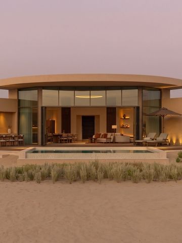 Moderne Villa mit großer Glasfront und Pool in der Wüste