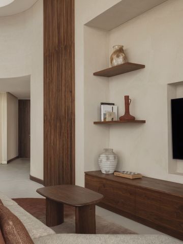 Moderner Wohnbereich mit Fernseher und dekorativen Elementen im Hotel Bab Al Shams