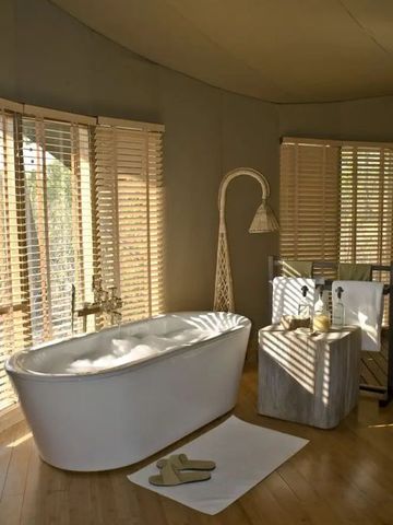 Luxuriöses Bad mit freistehender Badewanne und Holzjalousien