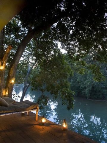 Terrasse mit Blick auf Fluss und Bäume bei Dämmerung