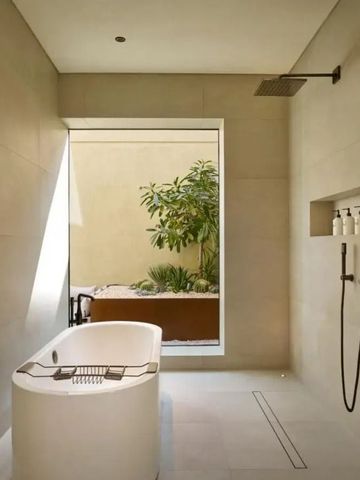 Luxuriöses Badezimmer mit freistehender Badewanne und Regendusche
