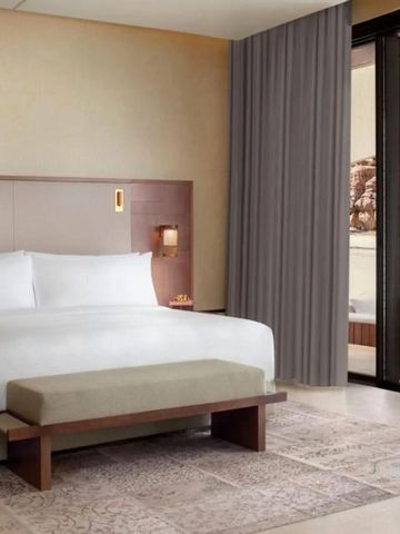 Modernes Schlafzimmer im Hotel Banyan Tree AlUla mit Blick auf die Terrasse