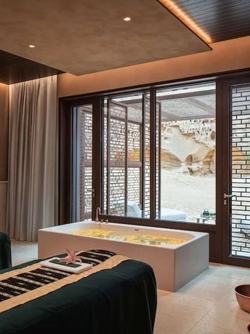 Innenraum eines Spa mit Massagebetten und Blick in eine Wüstenlandschaft