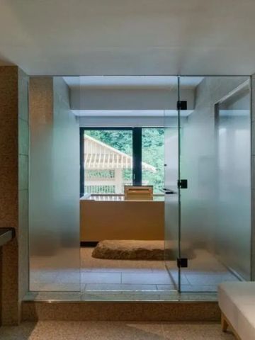 Badezimmer mit großer Duschkabine und Blick ins Freie