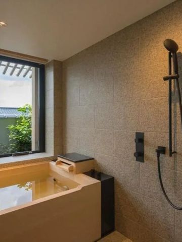 Geräumiges Badezimmer mit moderner Regendusche und Ausblick ins Grüne
