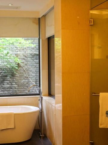 Modernes Badezimmer mit freistehender Badewanne und Gartenblick