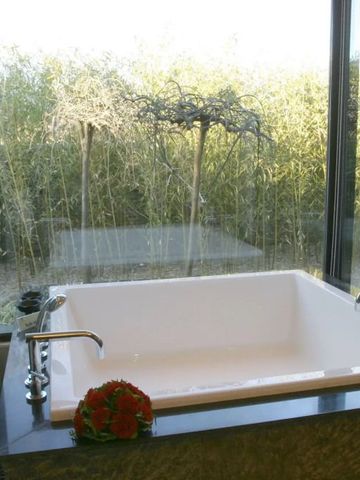 Luxuriöse Badewanne mit Blick auf einen begrünten Garten