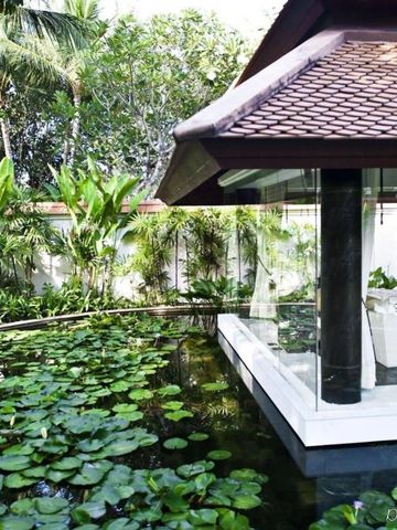 Glaspavillon umgeben von tropischem Garten mit Seerosen im Banyan Tree Phuket.