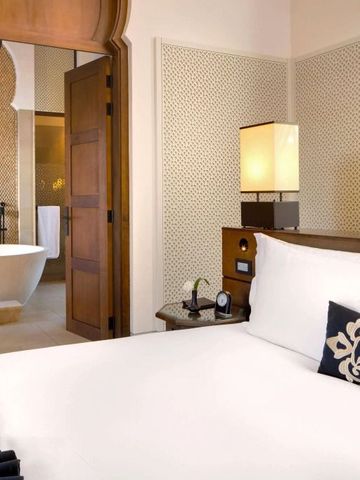 Elegantes Schlafzimmer mit Einblick in luxuriöses Badezimmer mit freistehender Badewanne