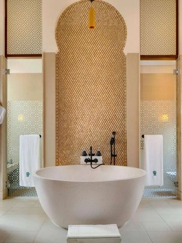 Geräumiges Badezimmer mit freistehender Badewanne und eleganten Wandverzierungen