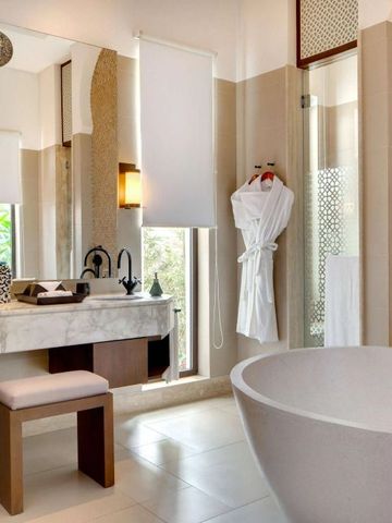 Modernes Badezimmer mit großer Badewanne und Marmorwaschtisch