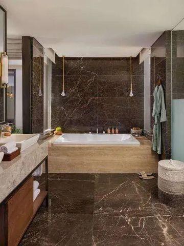 Luxuriöses Badezimmer aus Marmor mit Badewanne und Designer-Akzenten