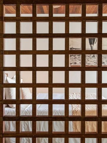Hotelzimmer mit stilvollem Holzgitter, das den Raum teilt und dekorative Details zeigt.