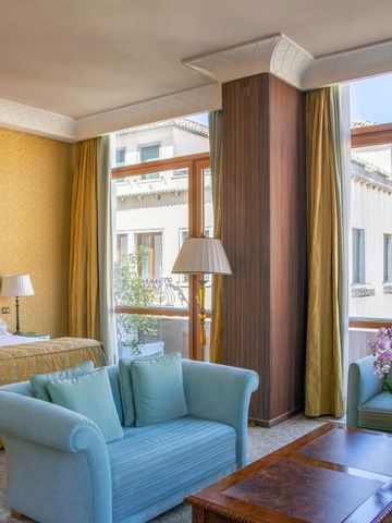 Helles Schlafzimmer mit großen Fenstern und elegantem Wohnzimmerbereich.