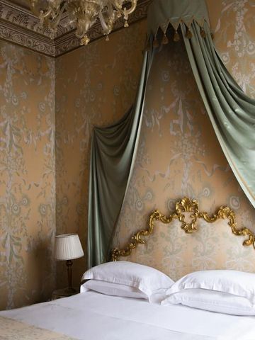 Luxuriöses Schlafzimmer mit Baldachin und vergoldetem Kopfteil