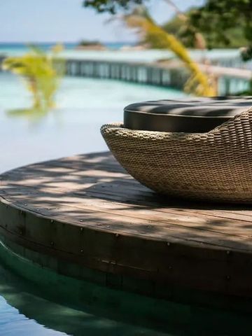 Infinity Pool mit Blick auf das Meer und einer Liege im Bawah Reserve