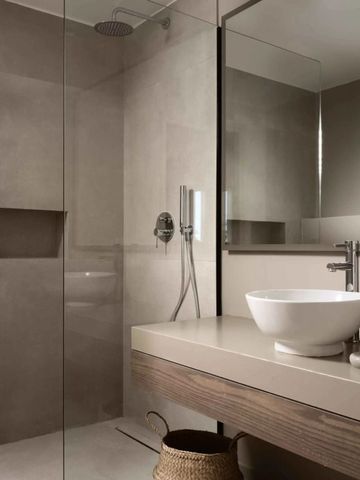 Modernes Badezimmer mit Regendusche und minimalistischer Einrichtung.