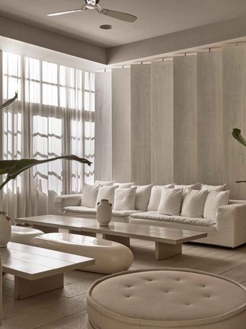 Moderne, elegante Lobby mit weißen Möbeln und großen Fenstern.