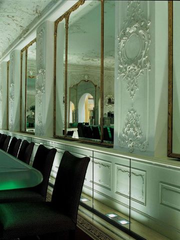 Elegante Bar mit kunstvollen Spiegeln und stilvoller Beleuchtung.
