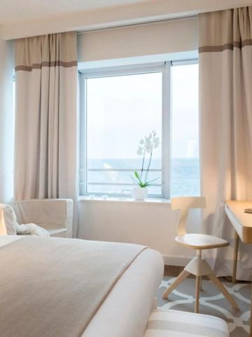 Komfortables Hotelzimmer mit Schreibtisch und Ausblick auf das Meer