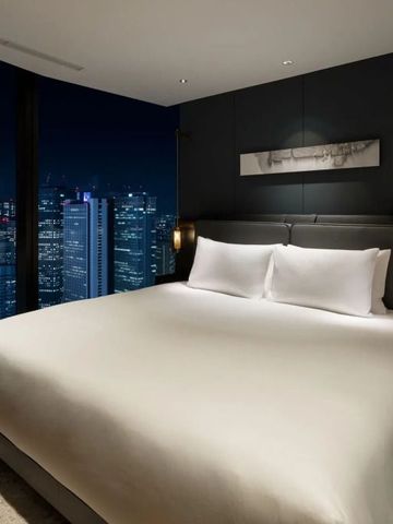 Komfortables Doppelbett in einem modernen Zimmer mit nächtlichem Stadtblick