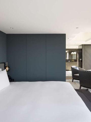 Zimmer mit stilvollem Interieur und Blick auf die Stadt durch große Fenster
