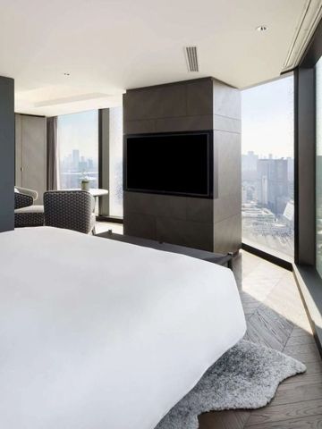 Großzügiges Zimmer mit Panoramafenstern und Tagesblick auf die Stadt