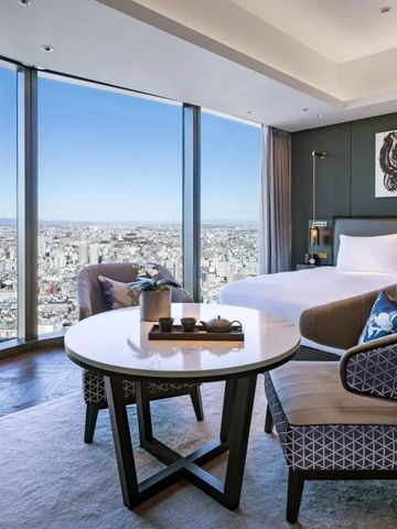 Helles Zimmer mit großem Fenster und Blick auf die Stadt
