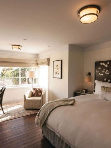 Lichtdurchflutetes Schlafzimmer mit elegantem Doppelbett und Sitzecke im El Encanto Santa Barbara