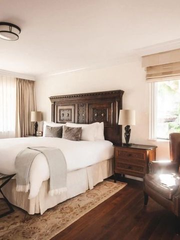 Elegantes Hotelzimmer mit luxuriösem Holzmobiliar und großer Fensterfront