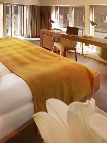 Geräumiges Hotelzimmer mit großen Fenstern und modernem Interieur