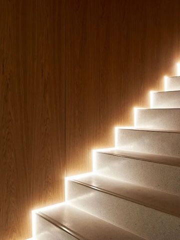 Modern beleuchtete Treppe mit Holzverkleidung im Hotel