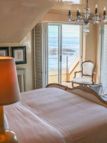 Gemütliches Schlafzimmer mit Meerblick und stilvollem Sessel.