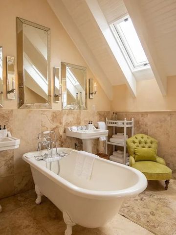Stilvolles Badezimmer mit freistehender Badewanne und grünen Akzenten
