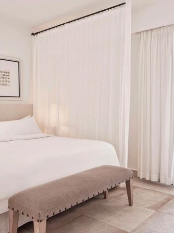 Minimalistisches Schlafzimmer mit Doppelbett und Zugang zur Terrasse
