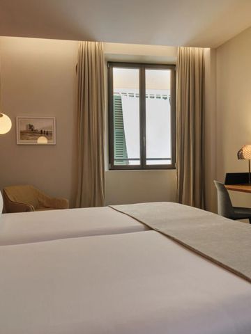Gemütliches Zimmer mit zwei Einzelbetten und elegantem Arbeitsplatz