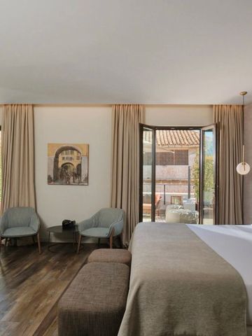 Geräumiges Zimmer mit großem Bett und Blick auf private Terrasse