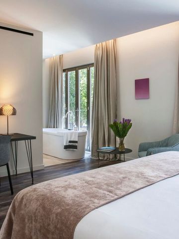 Helles Hotelzimmer mit großem Bett und Schreibtischbereich