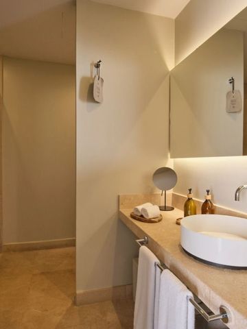 Geräumiges Badezimmer mit großer Spiegelwand und Waschbecken