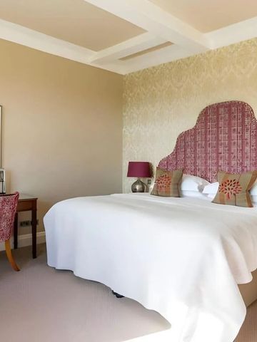 Elegantes Zimmer mit großem Bett und Schreibtisch im Bovey Castle