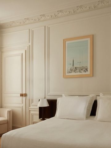 Helles Hotelzimmer mit klassischen Verzierungen und einem gemütlichen Doppelbett.