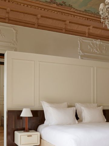 Luxuriöses Schlafzimmer mit aufwendiger Deckenverzierung und stilvoller Einrichtung.