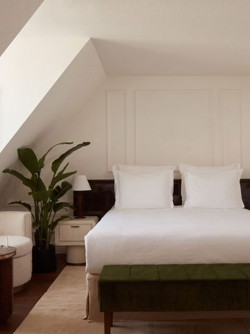 Elegantes Schlafzimmer mit Dachschräge, schickem Bett und moderner Einrichtung