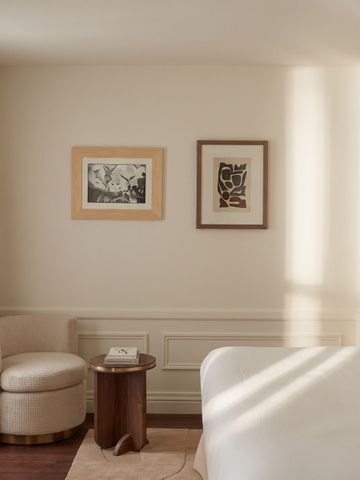 Helles Hotelzimmer mit gemütlicher Sitzecke und moderner Kunst an der Wand