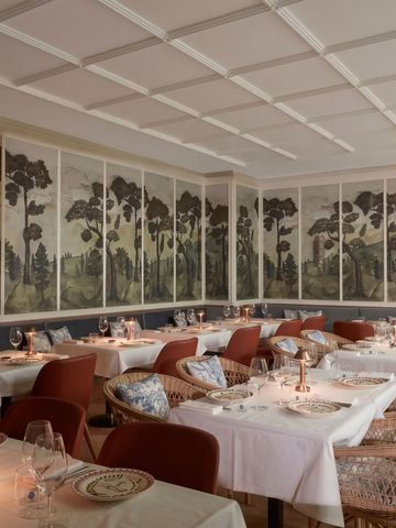 Schickes Restaurant mit künstlerischen Wandmalereien und eleganter Tischdekoration